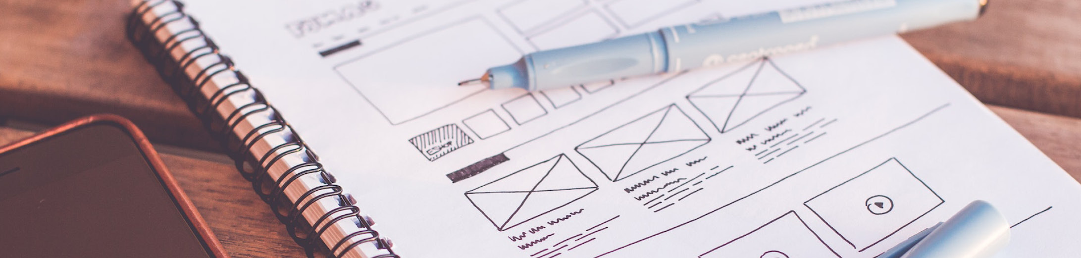 An image of a sketch book with a wire frame of a small business website