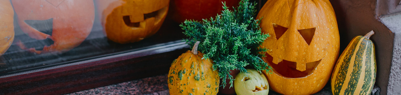 Carved pumpkin and mixed gourdes in a Halloween shop window