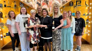Vilpa Lillie, Senior Lead at Yü Energy presenting the first Sustainable Yü Award to the Hays Travel Team in June 2026. 